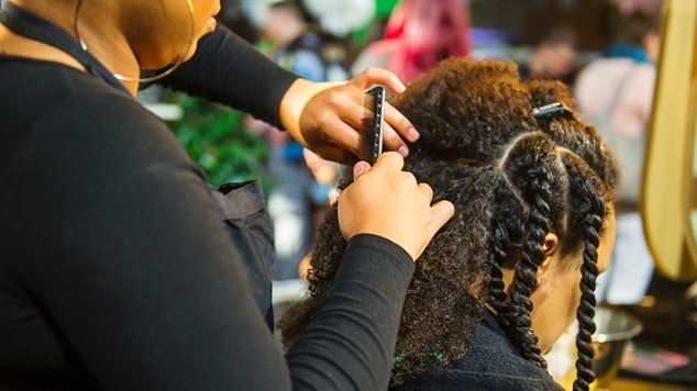 pessoa realizando penteados em uma pessoa de cabelo cacheado