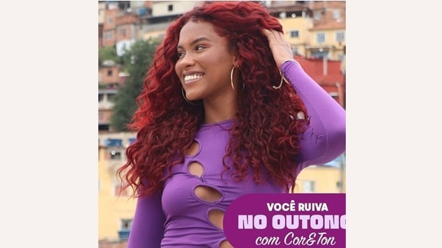 mulher de cabelos cacheados no tom vermelho borgonha