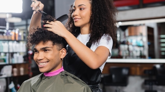 Homem jovem fazendo novo corte de cabelo masculino cacheado