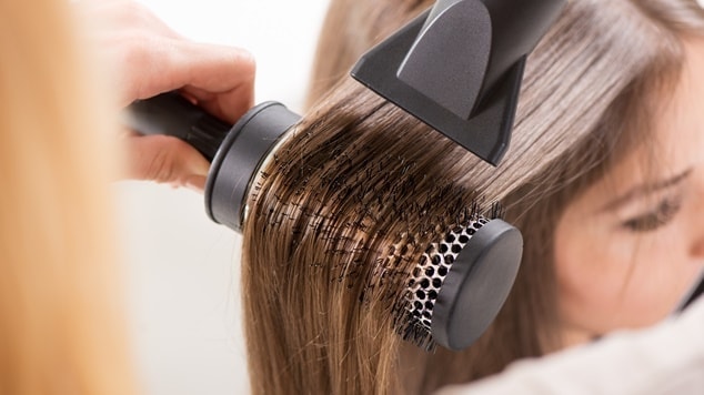 mulher de cabelo lisos sendo escovados por outra pessoa