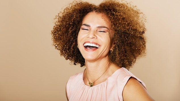  mulher com cabelos crespos volumosos, demonstra a beleza dos penteados para cabelo crespo.