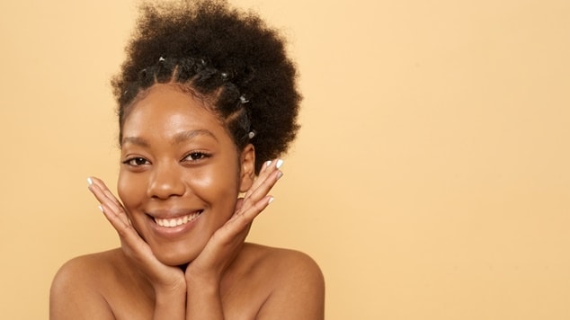 sorriso radiante e um penteado crespo que combina volume e tranças, uma mulher celebra a beleza natural do cabelo crespo.