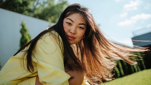 Jovem mulher com traços asiáticos e cabelos longos, conhecido como “cabelão”