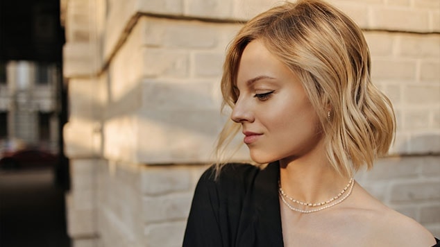 mulher de cabelo curto loiro dourado levemente alongado