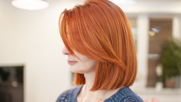 mulher com cabelo ruivo liso e franja lateral