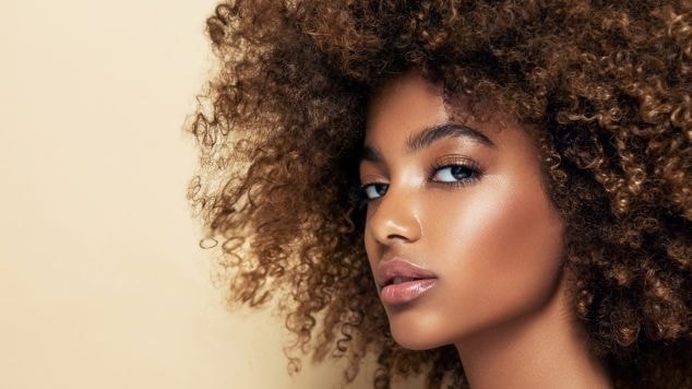 Mulher olhando para o lado esquerdo com cabelo crespo.