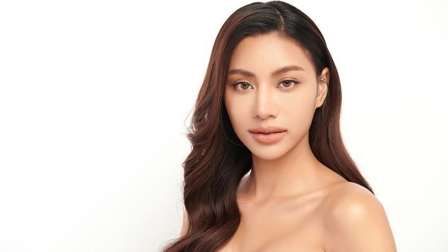 Mulher asiática com cabelo castanho escuro avermelhado.