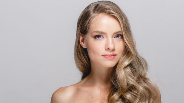 Mulher com cabelo loiro mel claro.