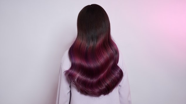 Mulher com cabelo castanho e violine.