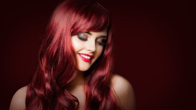 Mulher caucasiana sorrindo com cabelo vermelho amora