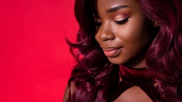 Mulher negra e elegante com o cabelo cor vermelho amora