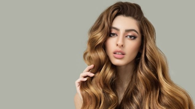 Mulher com cabelo longo na cor mel.