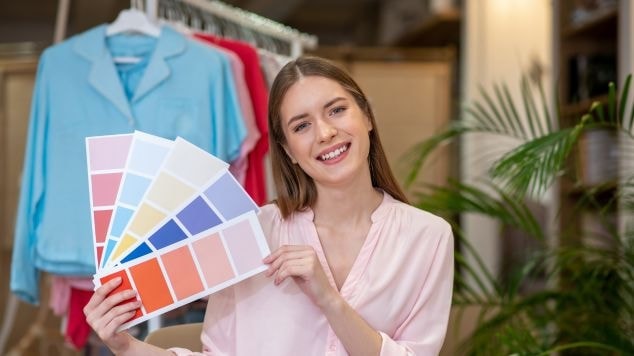 Mulher segurando cartões para fazer a coloração pessoal de uma pessoa.