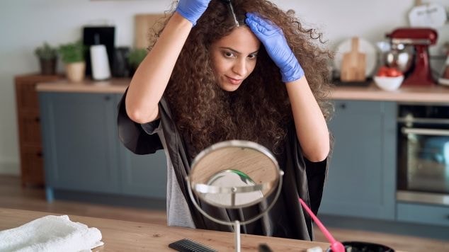 Mulher pintando o cabelo com tintura sem amônia. 