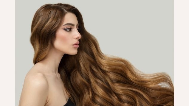 Mulher com cabelo cor de mel longo olhando para o lado direito.