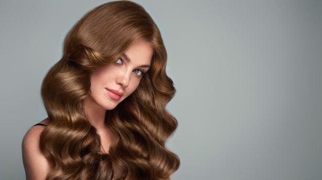 Mulher olhando para a câmera em fundo cinza.