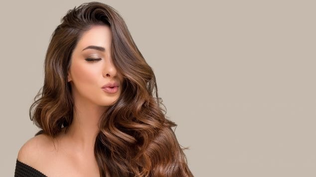 Mulher fazendo bico com a boca e com franja sobre a parte direita do rosto.