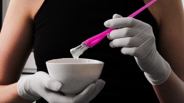 Mulher misturando a tinta sem amônia.