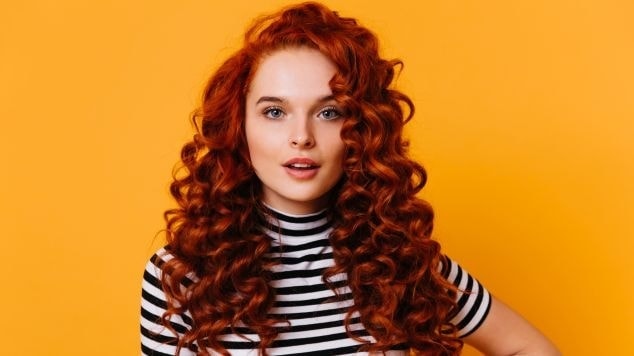Mulher ruiva com cor de cabelo tendência 2025.