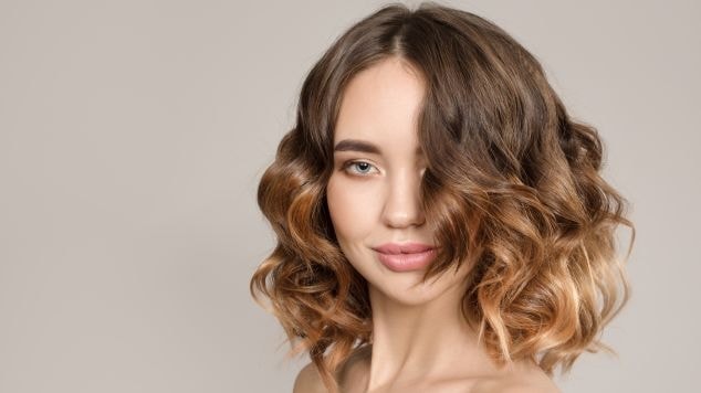 Menina com olhos claros e cabelo curto com ombre hair sutil em seu cabelo.