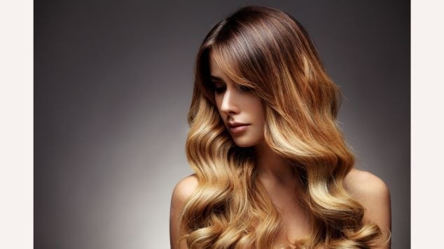 Mulher olhando para o lado esquerdo e cabelo com ombre hair bem esfumado na raiz.