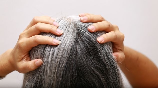 Mulher com fios brancos em seu cabelo.