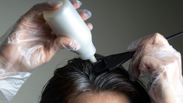 Mulher pintando os fios brancos com tonalizante.