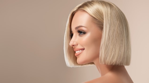 Mulher com cabelo curto loiro no corte blunt cut.