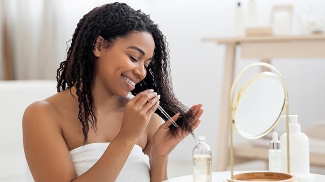 Mulher hidratando o cabelo no cabelo cacheado com manteiga de karite