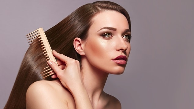 Mulher penteando o cabelo brilhante e macio.