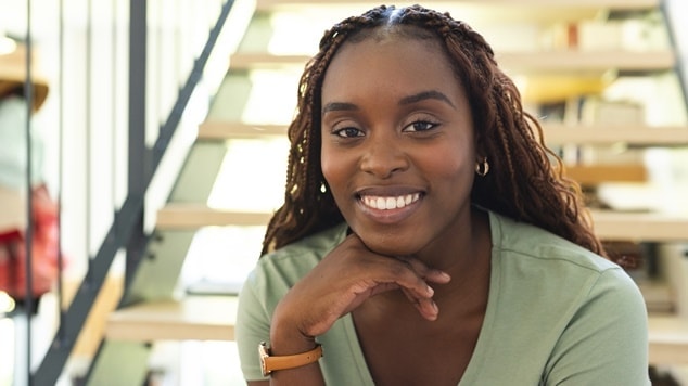 Garota negra usa tranças gypsy braids preto e sorri alegremente