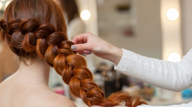 Mulher com cabelo ruivo e uma trança embutida nos fios.