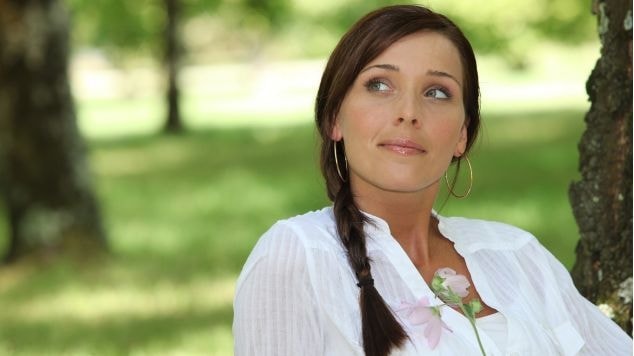 Mulher caucasiana no parque com tranças de lado.