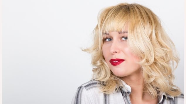 Mulher loira com cabelo shaggy hair médio.