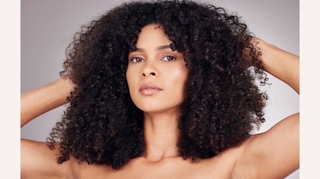 Mulher com cabelo shaggy hair cacheado e preto.