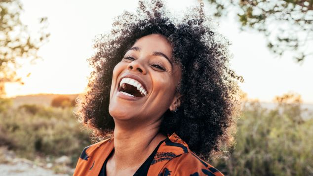 Mulher negra com cabelo cacheado após passar pela transição capilar com as dicas de Niely Gold