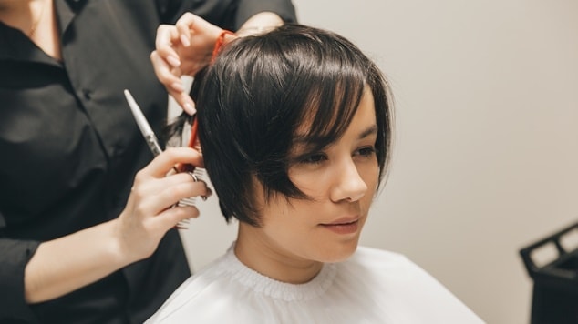 Mulher com corte pixie e franja longa.