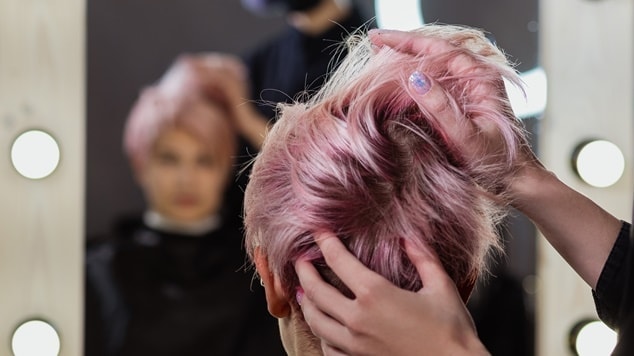 mulher com corte de cabelo pixie cor de rosa