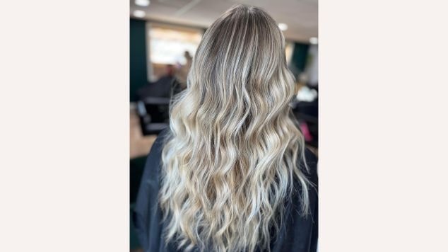 Foto de cabelo longo e ondulado com mechas platinadas