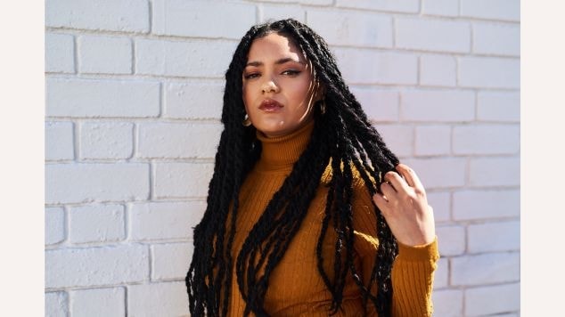 Mulher com a mão em seu cabelo com dreadlocks twist.