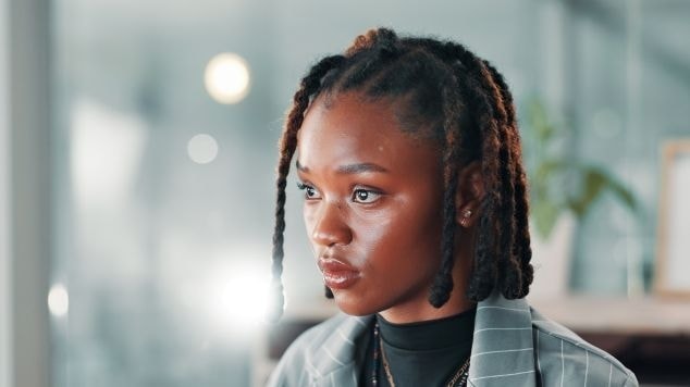 Mulher olhando para o lado esquerdo com dreadlocks curto em seu cabelo.