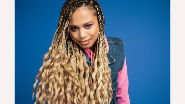 Mulher olhando para a câmera com gypsy braids em seu cabelo loiro.