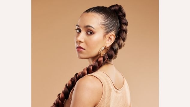 Mulher olhando para a câmera com trança boxeadora no cabelo.