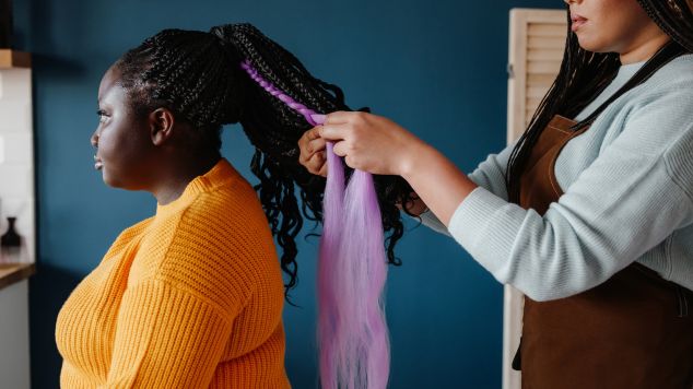 Profissional faz trança jumbo com cachos soltos em sua cliente
