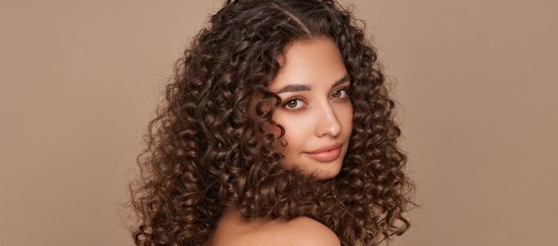 Mulher jovem com cabelos pintados com tinta castanha de cabelo.