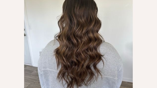 Foto do cabelo de uma jovem mulher com o tom de balayage morena iluminada avelã 