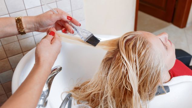 Profissional pinta o cabelo de sua cliente de acordo com a tabela de tinta de cabelo