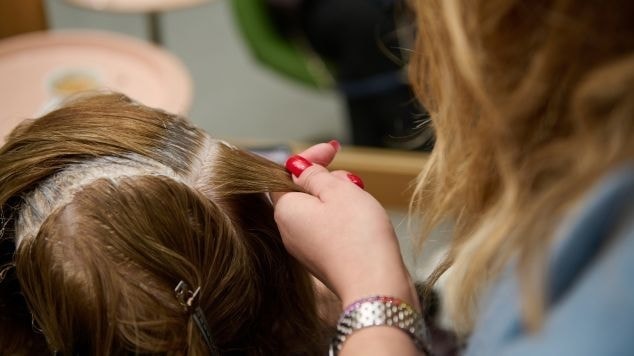 Profissional aplica tinta de cabelo em sua cliente de acordo com a tabela de cores de tinta de cabelo