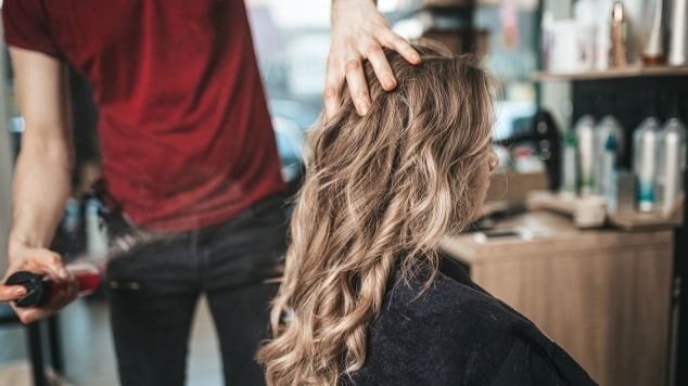 Mulher no salão de beleza depois de fazer luzes no cabelo com um profissional