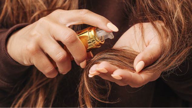 Mulher aplica um finalizador nas pontas do cabelo para proteger e reduzir o frizz no cabelo